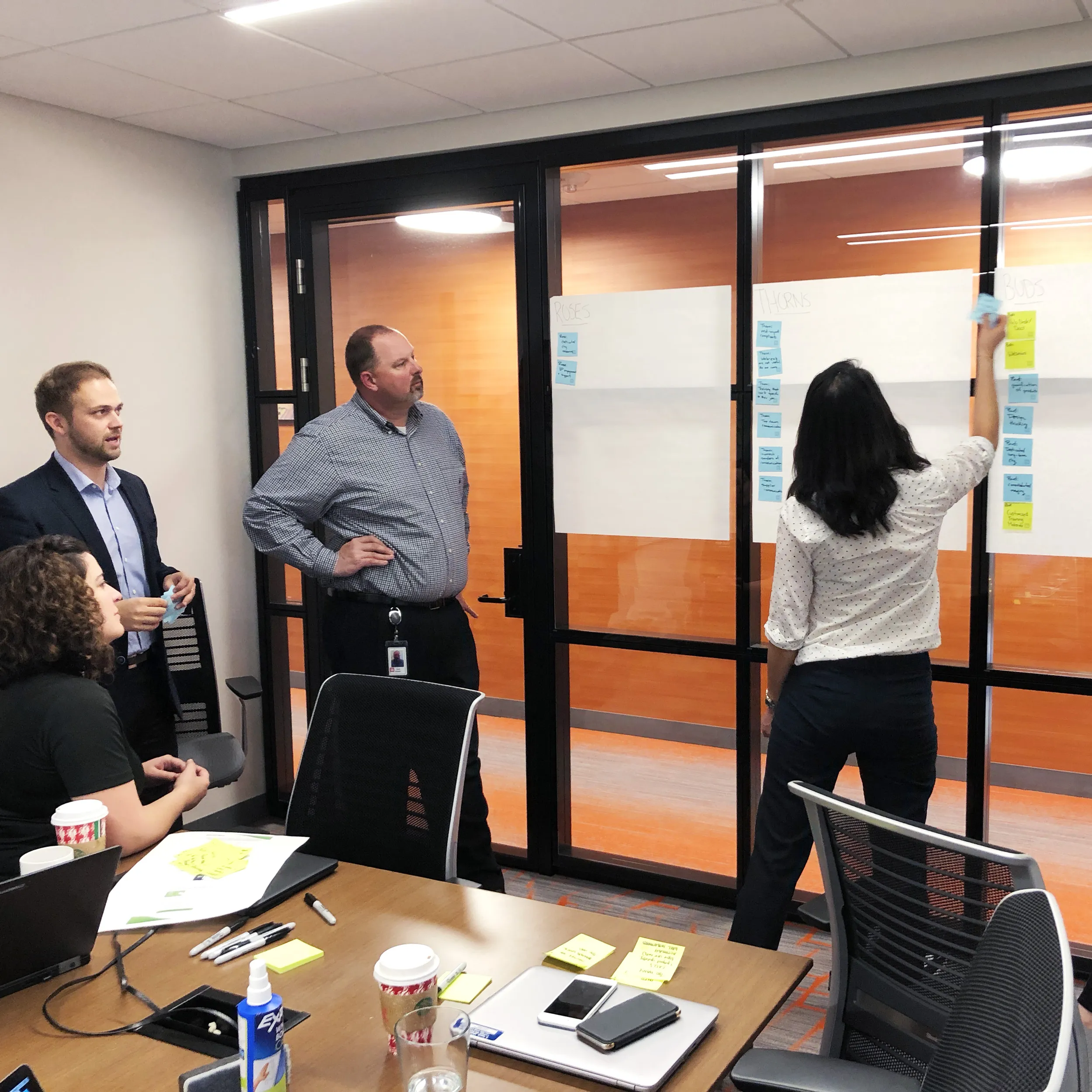 Team arranging sticky notes on a wall during planning session